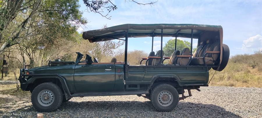 Another side view of the dark green open-sided Land Cruiser game viewer with a canopy roof